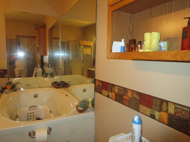 bathroom featuring a shower stall and a jetted tub