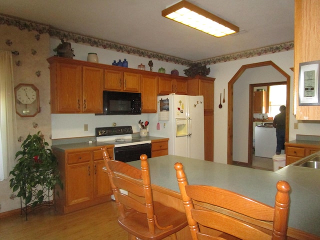 kitchen featuring electric stove, brown cabinets, black microwave, white fridge with ice dispenser, and light wood finished floors
