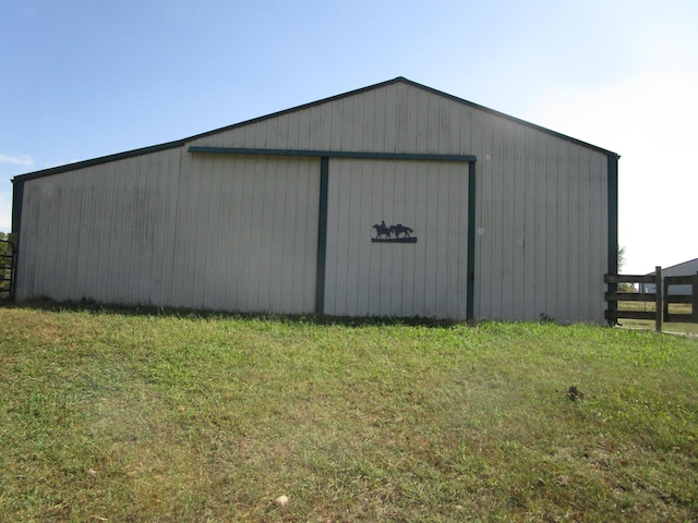 view of pole building with fence and a yard