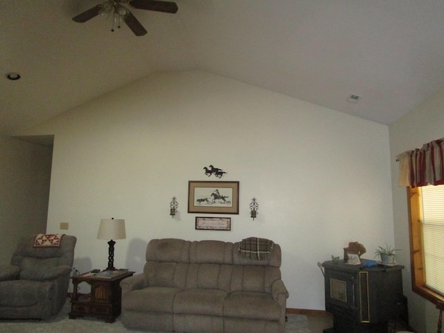 living area with lofted ceiling, a ceiling fan, visible vents, and a wood stove