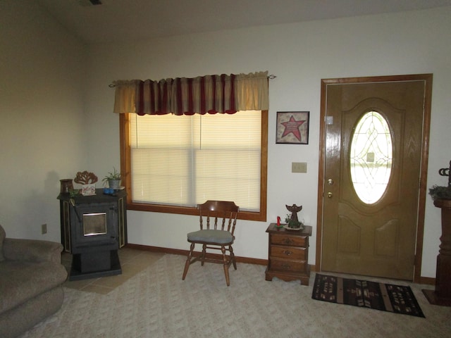 foyer featuring a wood stove and baseboards