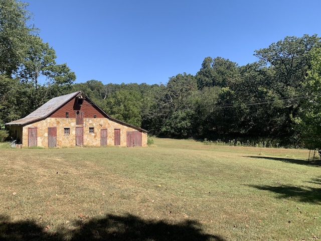 view of yard featuring a view of trees and an outbuilding