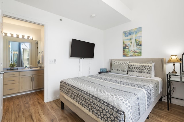 bedroom featuring connected bathroom and dark hardwood / wood-style flooring