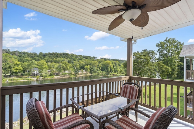 deck featuring ceiling fan, a yard, and a water view