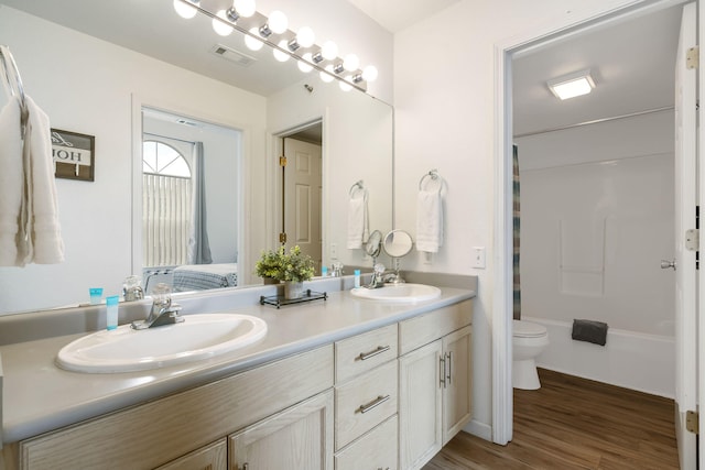 bathroom with hardwood / wood-style flooring, vanity, and toilet