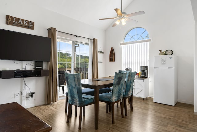 dining space with ceiling fan, hardwood / wood-style flooring, vaulted ceiling, and a wealth of natural light