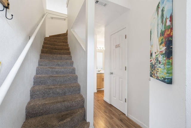 stairs featuring hardwood / wood-style floors