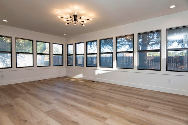 unfurnished sunroom featuring an inviting chandelier