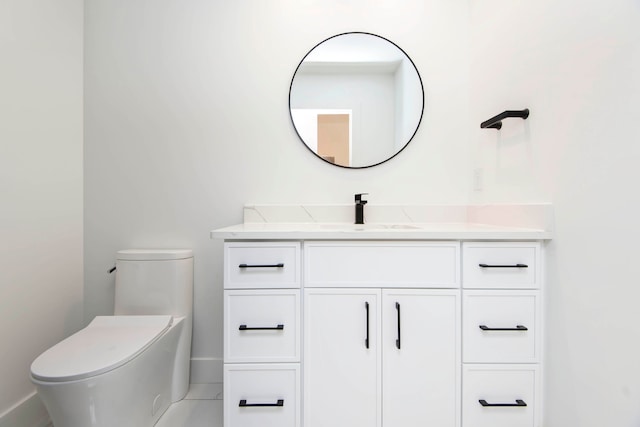 bathroom with toilet, vanity, and tile patterned floors