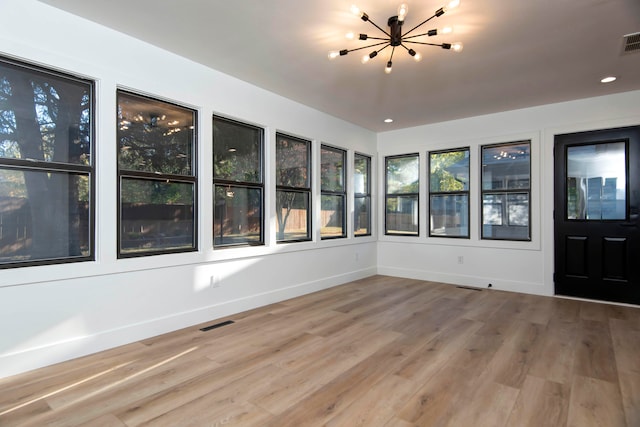 unfurnished sunroom with an inviting chandelier