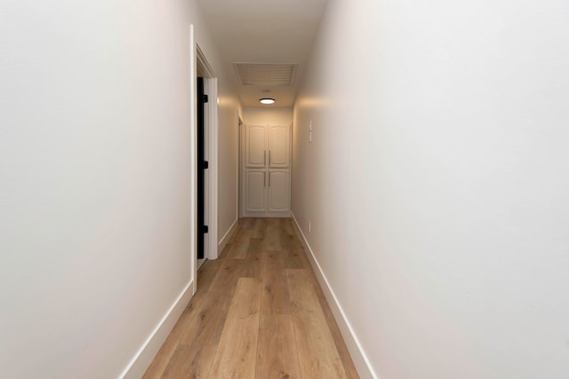 hallway with light hardwood / wood-style floors