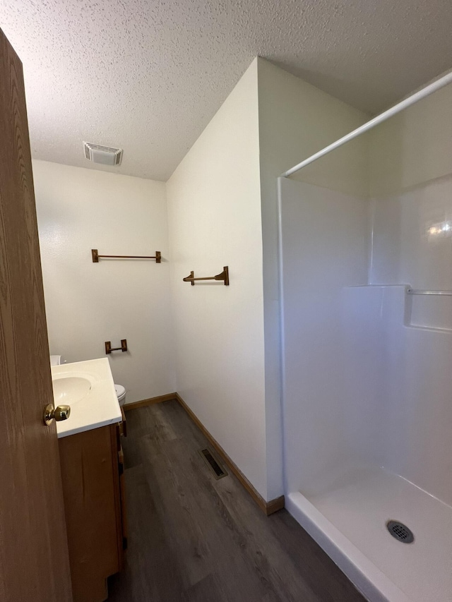 328 E 4th St, Willow Springs, MO 65793 - full bathroom with a walk in shower, vanity, wood finished floors, and visible vents