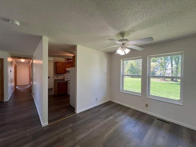 spare room with ceiling fan, a textured ceiling, and dark hardwood / wood-style floors