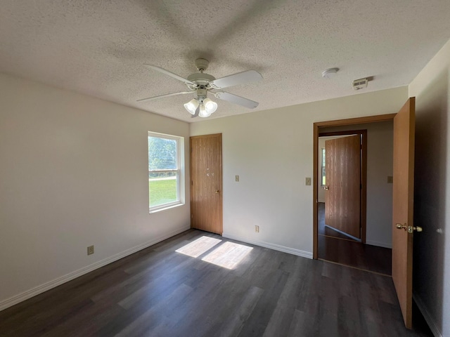 unfurnished room with ceiling fan, a textured ceiling, and dark hardwood / wood-style flooring