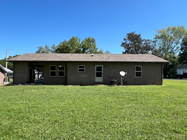 rear view of property featuring a lawn