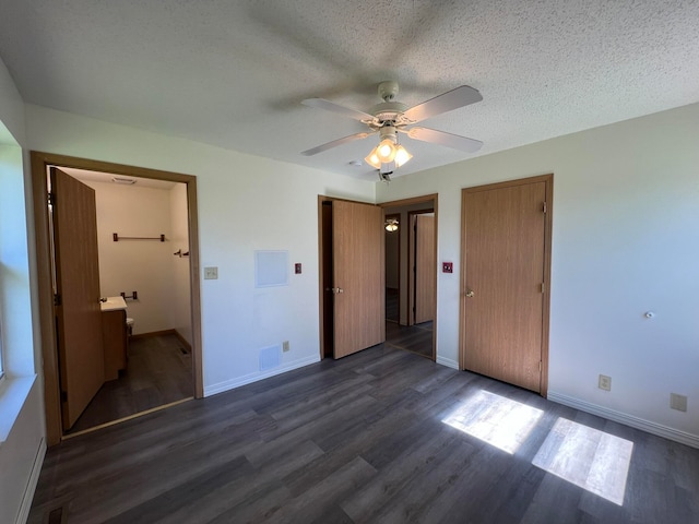 unfurnished bedroom featuring a textured ceiling, ensuite bathroom, ceiling fan, and dark hardwood / wood-style flooring