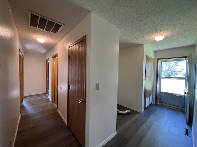 328 E 4th St, Willow Springs, MO 65793 - hall featuring wood finished floors, a textured ceiling, baseboards, and visible vents
