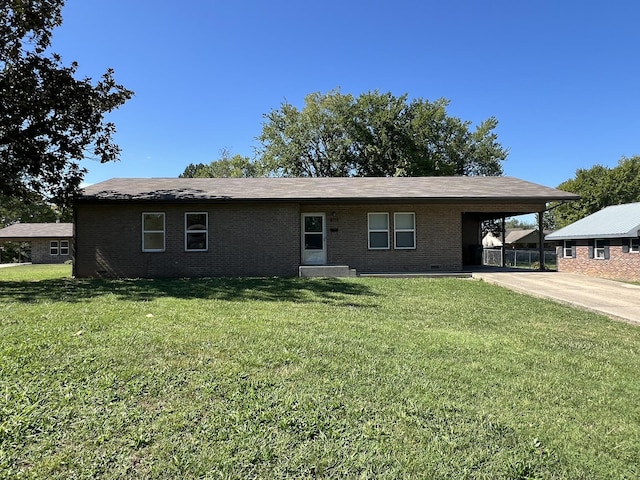 328 E 4th St, Willow Springs, MO 65793 - view of front facade with a carport, a front lawn, brick siding, and concrete driveway