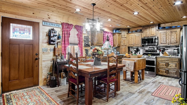 dining area with a notable chandelier, wood walls, wood ceiling, and light hardwood / wood-style flooring