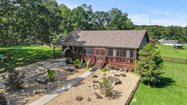 view of front of house with a front lawn and a sunroom