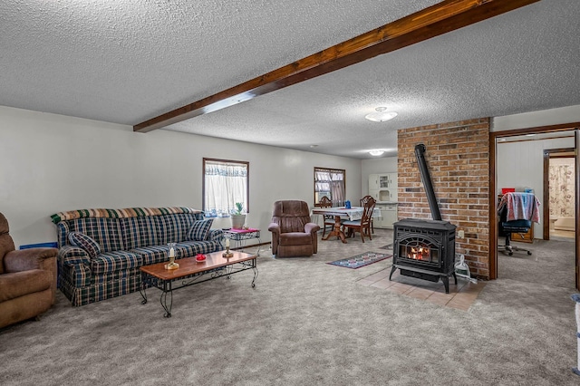 living room with light colored carpet, a textured ceiling, beam ceiling, and a wood stove