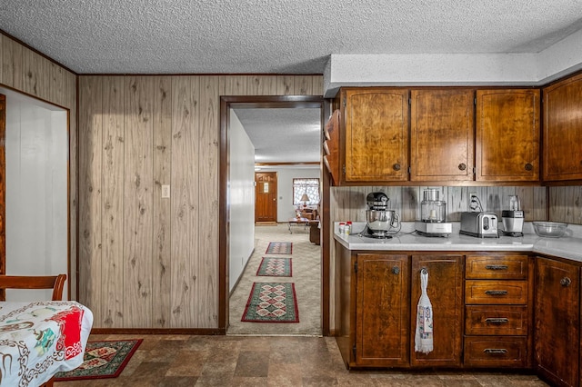 kitchen featuring wood walls and a textured ceiling