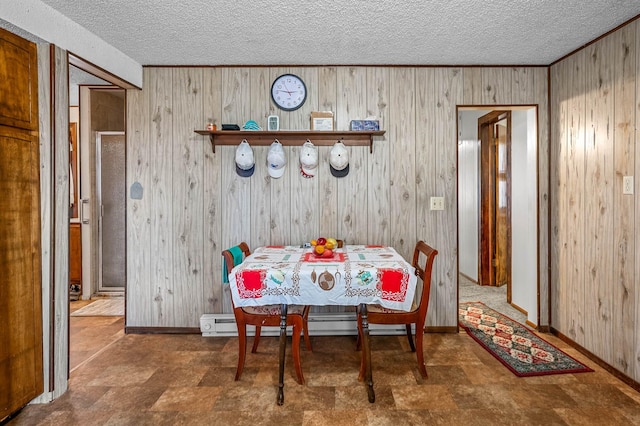 dining area with wooden walls and a textured ceiling