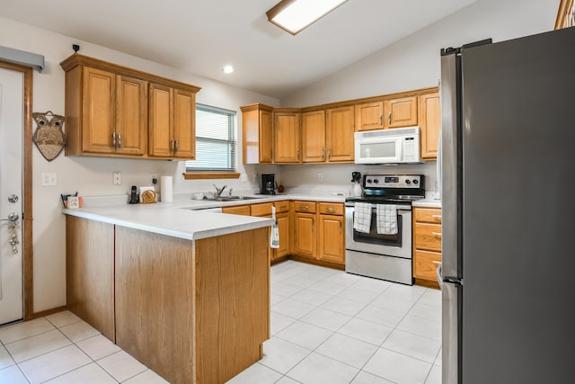 kitchen with lofted ceiling, sink, light tile patterned flooring, kitchen peninsula, and stainless steel appliances