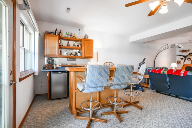 bar with stainless steel appliances, ceiling fan, and light colored carpet