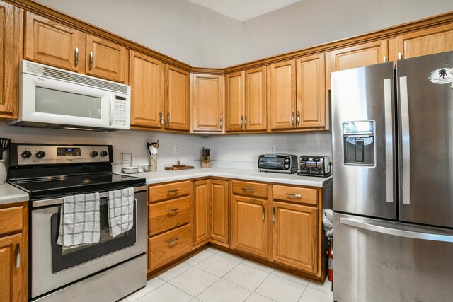 15 Bay Front Ln Apt A, Kimberling City, MO 65686 - kitchen with appliances with stainless steel finishes, light tile patterned flooring, light countertops, and brown cabinetry