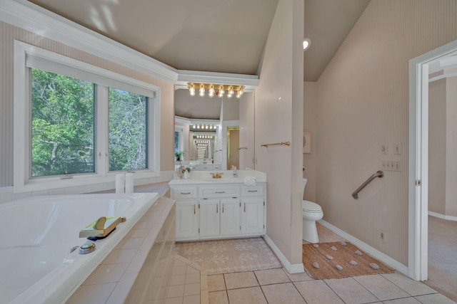 bathroom with tile patterned flooring, tiled tub, vaulted ceiling, toilet, and vanity