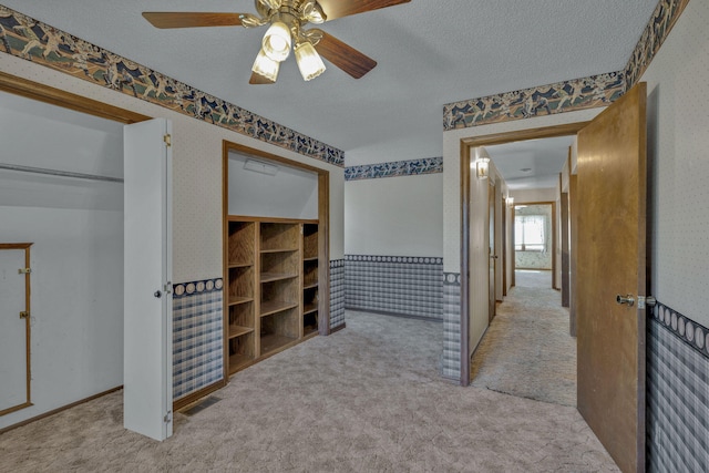 interior space featuring light colored carpet and a textured ceiling