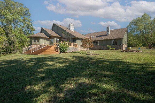 rear view of property with a yard and a wooden deck