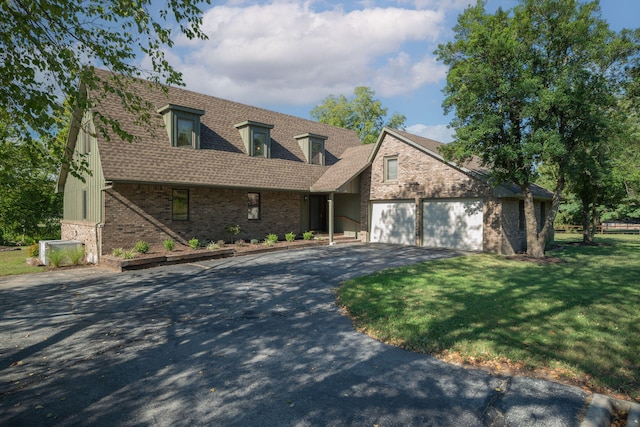 cape cod home featuring a front yard and a garage