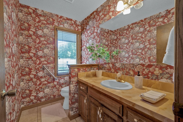 bathroom with tile patterned flooring, vanity, a textured ceiling, and toilet