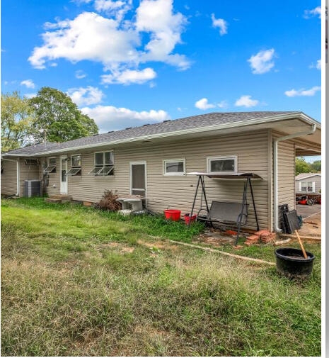 rear view of property featuring a lawn