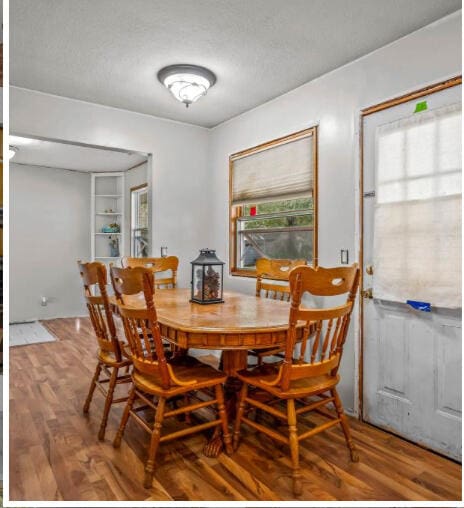 dining area featuring wood-type flooring and a textured ceiling