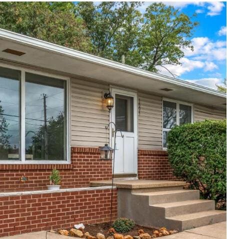 doorway to property featuring brick siding