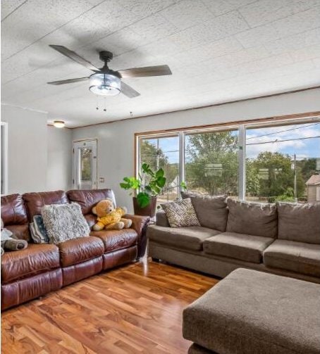 living area with wood finished floors and ceiling fan