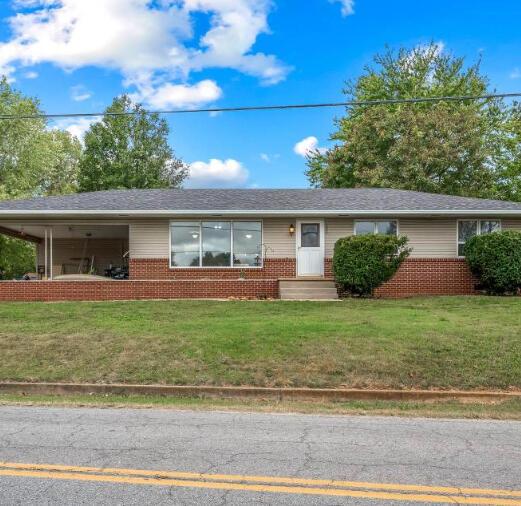 ranch-style home featuring brick siding and a front yard