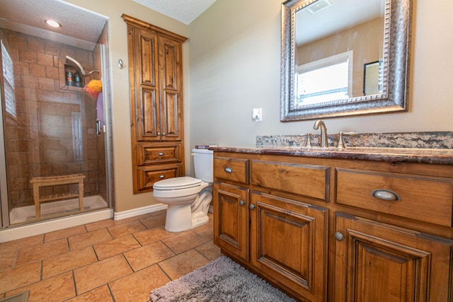 bathroom with a textured ceiling, walk in shower, vanity, and toilet