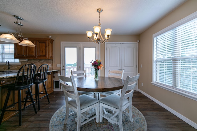 dining space with plenty of natural light, dark hardwood / wood-style floors, and a textured ceiling