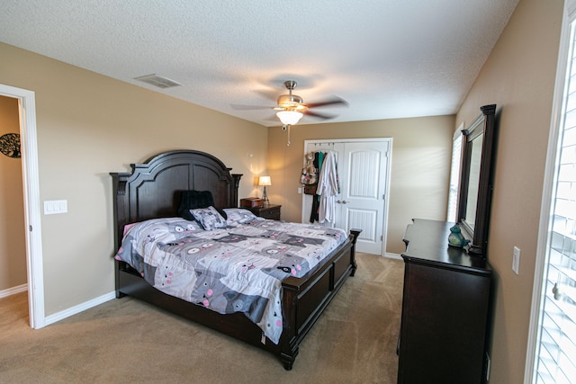 bedroom featuring carpet, a textured ceiling, and ceiling fan