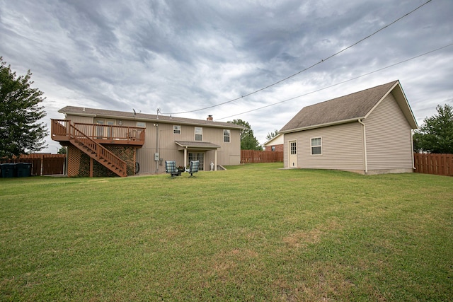 back of property featuring a wooden deck and a yard