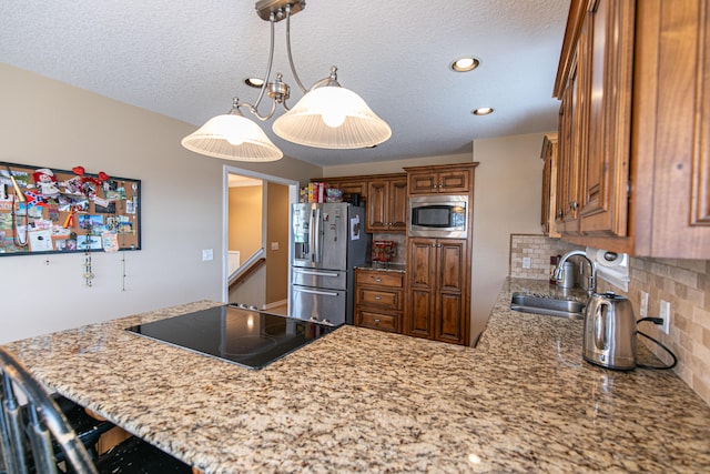 kitchen with decorative light fixtures, sink, decorative backsplash, appliances with stainless steel finishes, and a textured ceiling