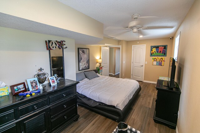 bedroom featuring dark hardwood / wood-style floors, a textured ceiling, and ceiling fan