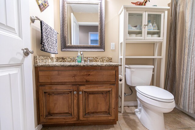 bathroom featuring vanity, tile patterned flooring, and toilet