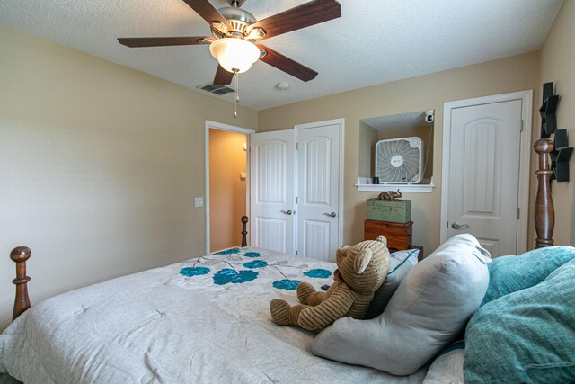 bedroom featuring ceiling fan and a textured ceiling