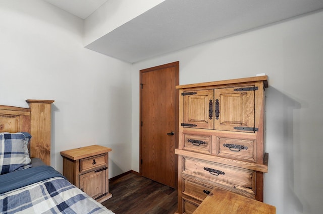 bedroom with dark hardwood / wood-style flooring