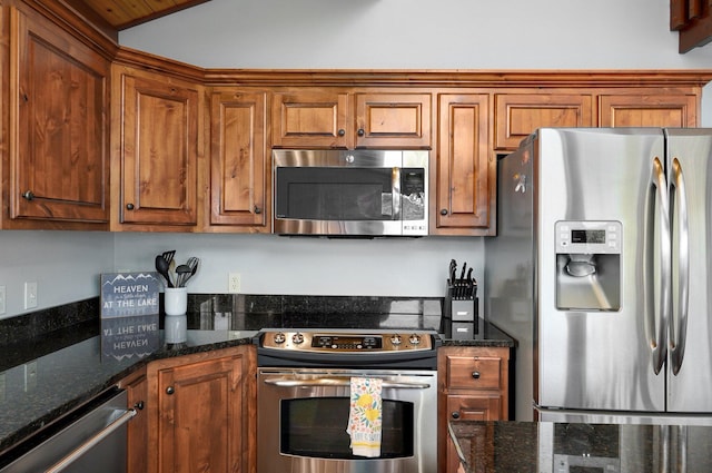 kitchen featuring lofted ceiling, dark stone countertops, and appliances with stainless steel finishes